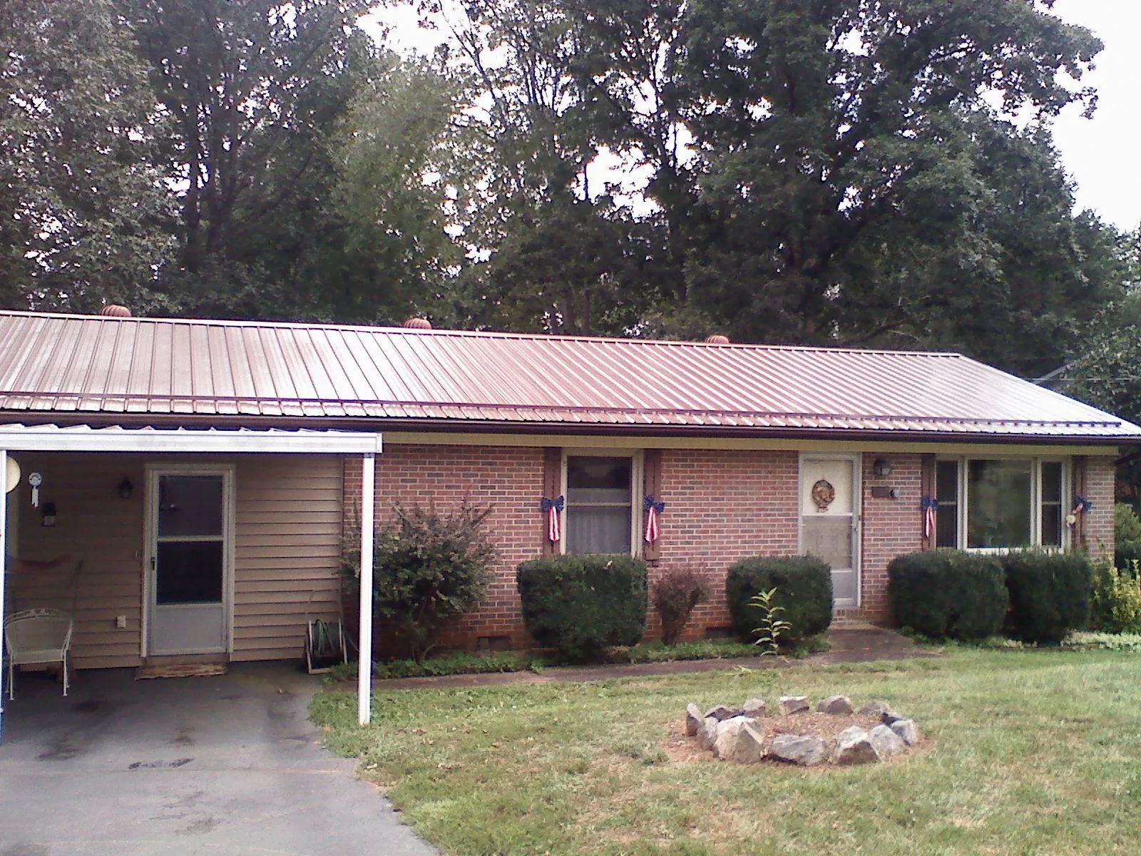 Bronze metal roof and carport on a brick ranch home — Roof Repair work by our crew in Aledo