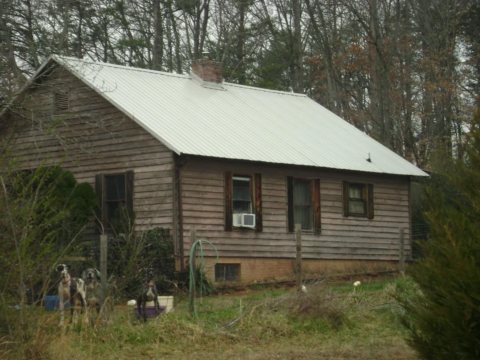 White metal roof on an old wood sided farmhouse, from a Metal Roof Installation job in Aledo